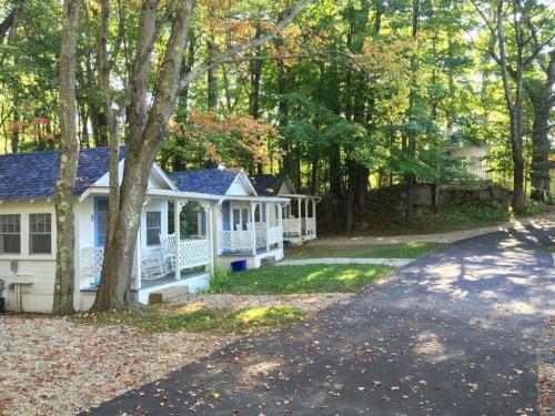 a house with a porch and a driveway at 2 River Road Inn Cottages in Cape Neddick