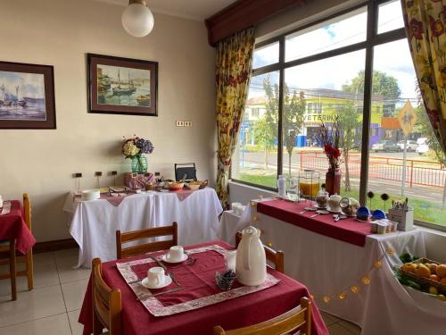 a dining room with two tables and a window at Hotel Libertador Bernardo O´Higgins in Chillán