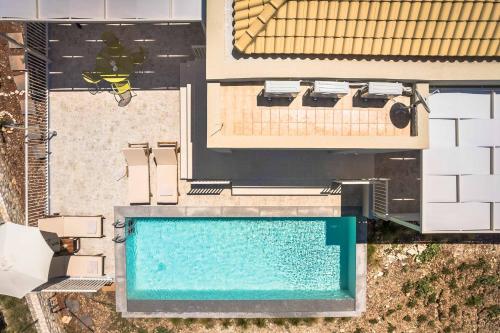 an overhead view of a swimming pool next to a building at Levantes Villa in Divarata