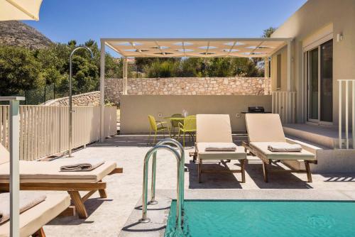 a patio with a pool and chairs and a table at Levantes Villa in Divarata