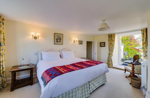 Un dormitorio con una cama grande y una ventana en Trevadlock Manor Self Catering Cottages, en Launceston