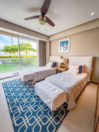a bedroom with two beds and a large window at Spectacular Ocean front 5BR condo in Bolongo in Punta Mita