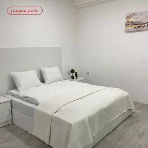 biała sypialnia z dużym łóżkiem z białą pościelą w obiekcie La Maisson Blanche Baku w mieście Baku