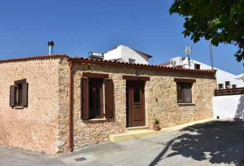 un edificio in mattoni con porta e finestre di ESTIA stone house a Vrísai