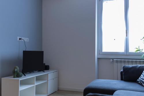 ein Wohnzimmer mit einem TV und einem Sofa in der Unterkunft Luminous Home Roma Trastevere in Rom