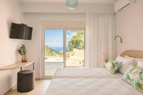 a bedroom with a bed and a sliding glass door at Punentes Villa in Divarata