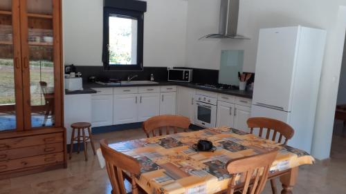 une cuisine avec une table avec des chaises et un réfrigérateur dans l'établissement Cabanon le sarazin, à Puyvert