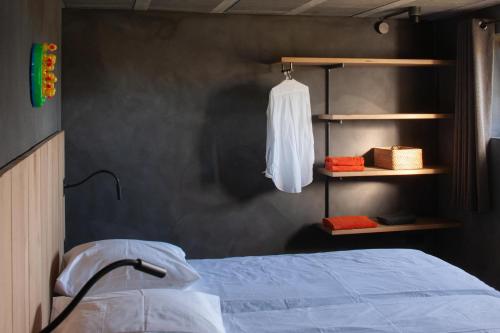 1 dormitorio con 1 cama y una camisa blanca en un estante en Nouveau! Gîte contemporain entouré de 10 étangs, en Florennes