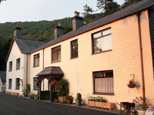 a white building with a gazebo on a street at Padarn Apartment at Glanybala Holidays in Llanberis