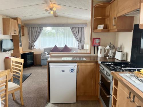 a kitchen with a white refrigerator and a stove at 3 Bedroom Self Catering Static Caravan in Steps