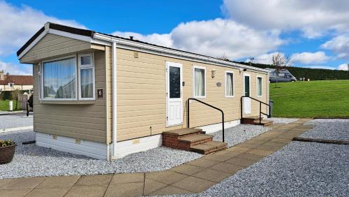 a tiny house sitting on a gravel lot at 3 Bedroom Self Catering Static Caravan in Steps