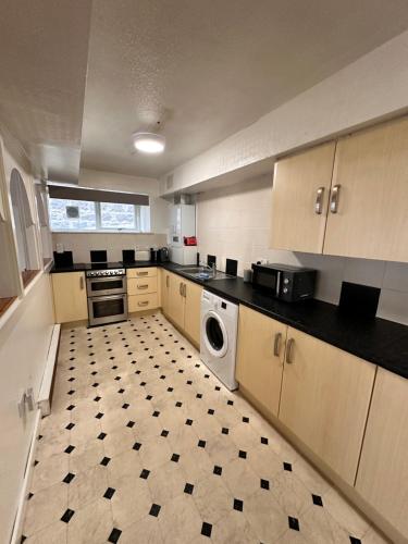 a large kitchen with a washer and dryer in it at Gilcomston Park in Aberdeen