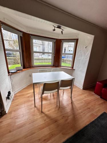 una sala da pranzo con un tavolo bianco e due sedie di Gilcomston Park ad Aberdeen