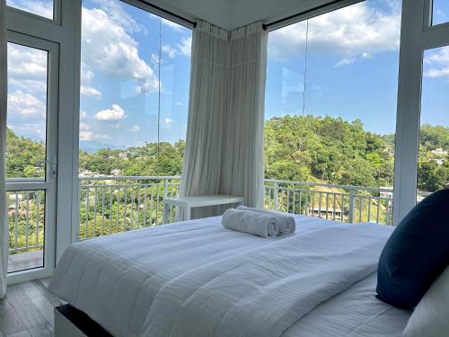 een bed in een kamer met grote ramen bij Secret Heaven Kandy in Kandy