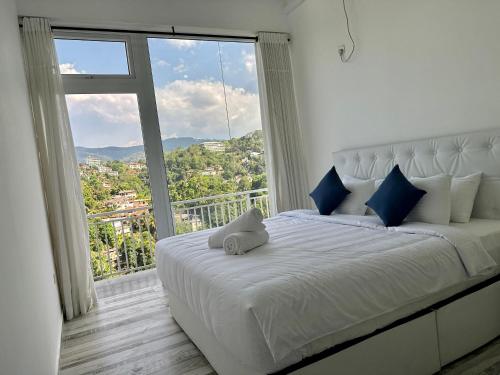 a bed with a stuffed animal on it in a room with a window at Secret Heaven Kandy in Kandy