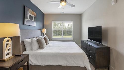 Schlafzimmer mit einem Bett und einem Flachbild-TV in der Unterkunft Landing at 11th and Spruce - 2 Bedrooms in Downtown in Saint Louis