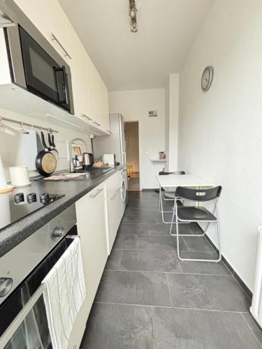 eine Küche mit einer Theke und einem Tisch darin in der Unterkunft Cozy Apartment in Hannover Central in Hannover