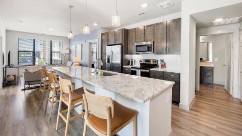 a kitchen with a large island in a kitchen with wooden cabinets at Landing at 11th and Spruce - 2 Bedrooms in Downtown in Saint Louis