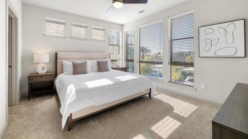 Dormitorio blanco con cama y ventana grande en Landing at 11th and Spruce - 2 Bedrooms in Downtown, en Saint Louis