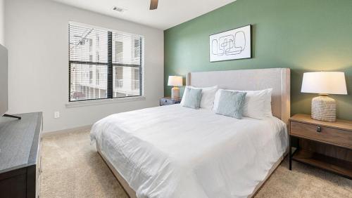 1 dormitorio con cama blanca y ventana en Landing at 11th and Spruce - 2 Bedrooms in Downtown, en Saint Louis