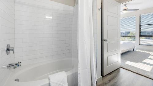 a white bath tub in a bathroom with a window at Landing at 11th and Spruce - 2 Bedrooms in Downtown in Saint Louis