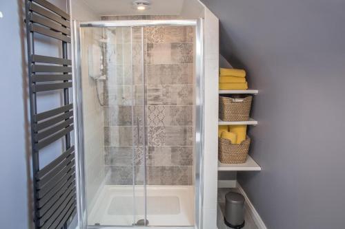 a shower with a glass door in a bathroom at Connemara Letting's Townhouse in Clifden