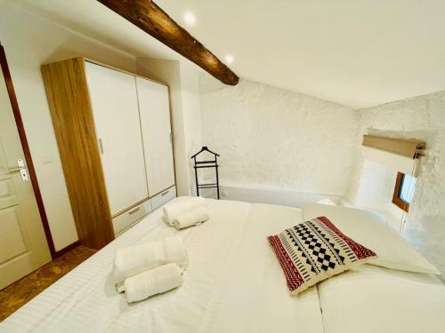 - un lit blanc avec 2 oreillers dans l'établissement Appartement F2 