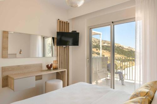 a bedroom with a bed and a desk and a balcony at Ostria Villa in Divarata