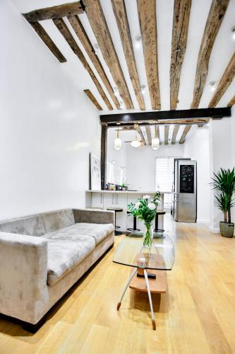 un salon avec un canapé et une table dans l'établissement Marais 4 bedrooms new apartment, à Paris