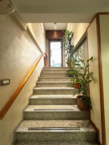 a staircase with potted plants in a hallway at Hotel Le Querce in Milan
