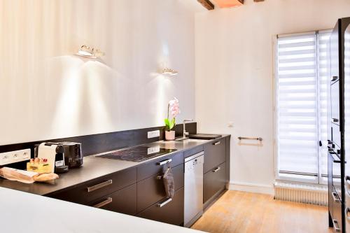 - une cuisine avec un plan de travail noir et un évier dans l'établissement Marais 4 bedrooms new apartment, à Paris