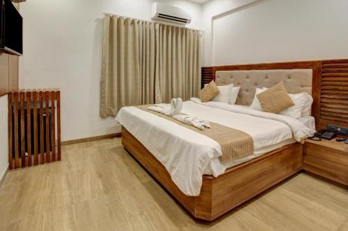 a bedroom with a large bed with white sheets at HOTEL EVERSHINE in Rajkot