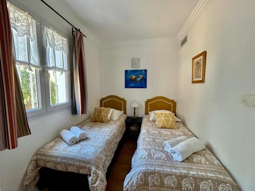 two twin beds in a room with windows at Les Restanques Cabrière 3024 in Grimaud