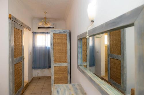 uma casa de banho com um espelho, um lavatório e uma janela em Sarges Hotel em Sere Kunda