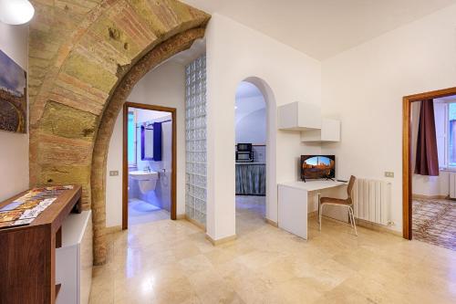 a large room with an archway and a bathroom at Elehome2 nel cuore della città in Siena