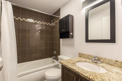 Un baño con lavabo, inodoro y bañera. en The Grand Prix Suite In the heart of MTL - M11 Rentals, en Montreal