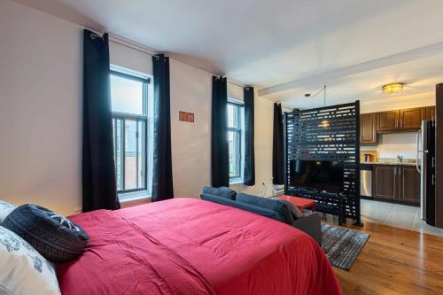 1 dormitorio con 1 cama grande de color rojo y cocina en The Grand Prix Suite In the heart of MTL - M11 Rentals, en Montreal