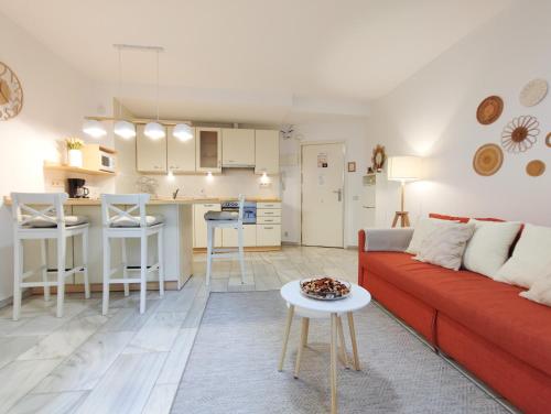 マドリードにあるDFLAT Escultor Madrid Apartmentsのリビングルーム(赤いソファ付)、キッチン