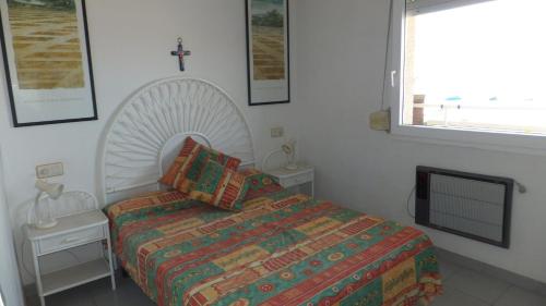 1 dormitorio con 1 cama y 1 cruz en la pared en Roc Mar 2 5C - Apartamento cerca del centro y de la playa - terraza con vistas al mar y al puerto, en Roses