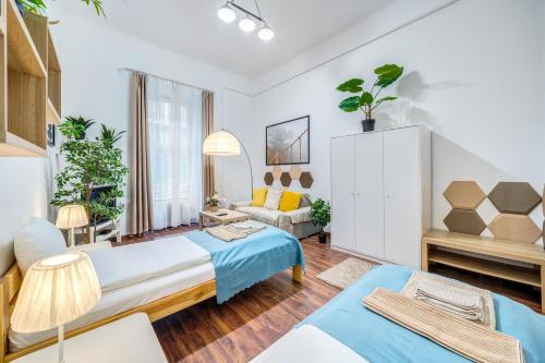 ブダペストにあるDiamond Residence - BimBam Bajzaのベッド2台とソファが備わるホテルルームです。