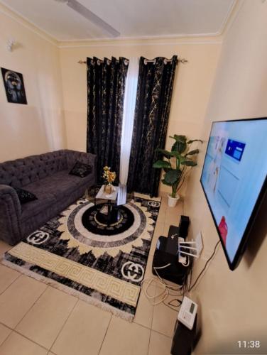 sala de estar con sofá y TV de pantalla plana en Petra Homes, en Mombasa