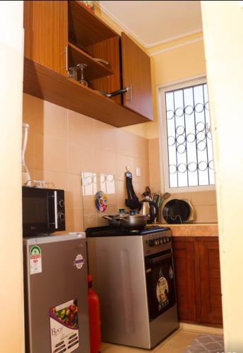 cocina con nevera de acero inoxidable y microondas en Petra Homes, en Mombasa