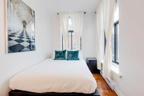 1 dormitorio con 1 cama blanca grande con almohadas azules en M11 Gorgeous Bright Corner 2BR in Heart of MTL, en Montreal