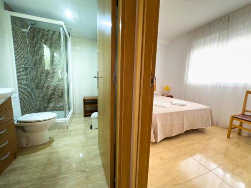 baño con cama, aseo y ventana en Acogedor apartamento cerca de la playa wifi y parking, en Mont-roig
