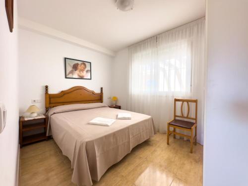 1 dormitorio con 1 cama, 1 silla y 1 ventana en Acogedor apartamento cerca de la playa wifi y parking, en Mont-roig
