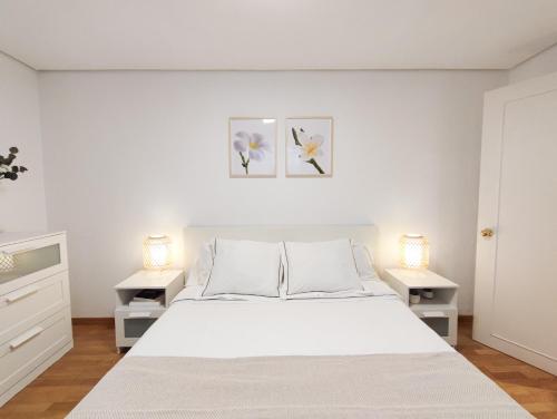 1 dormitorio con 1 cama blanca y 2 mesitas de noche en DFLAT Escultor Madrid Apartments, en Madrid