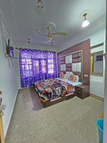 a bedroom with a large bed and a purple curtain at Sona Palace in Srinagar