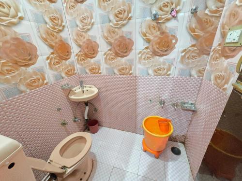 a bathroom with a toilet and a sink with donuts on the wall at Sona Palace in Srinagar
