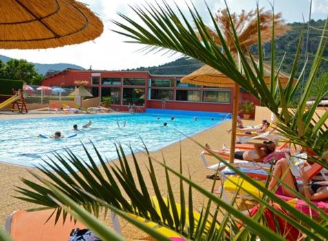 une grande piscine avec des gens qui nagent dedans dans l'établissement Camping Cascade Aveyron, à Saint-Rome-de-Tarn
