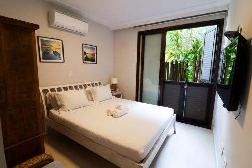 a bedroom with a bed with a television and a window at Condomínio Quinta de Juquehy - Prime Lok in Juquei